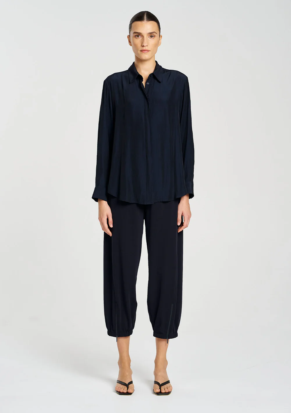 Woman wearing a navy blue outfit on a white background