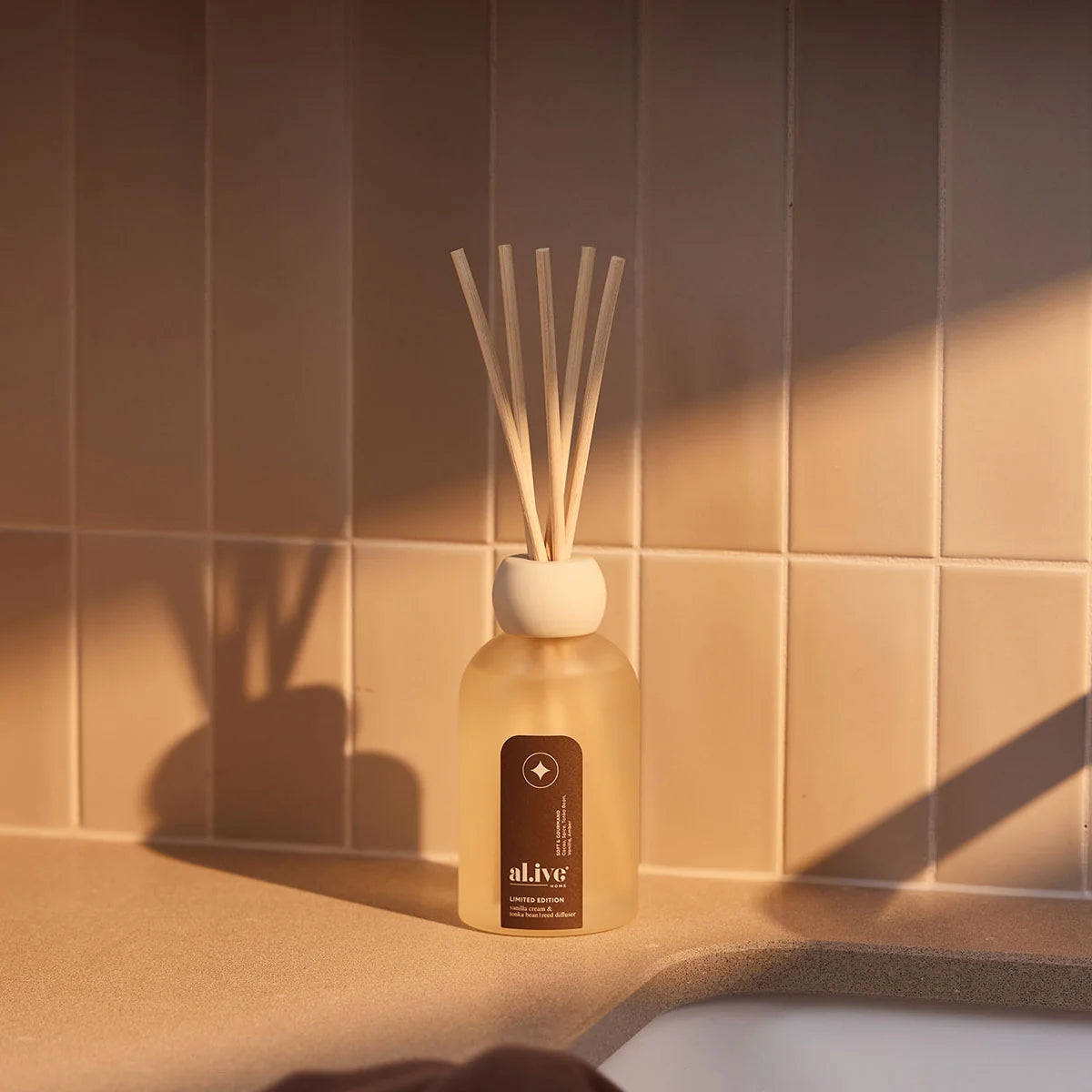 al.ive body Limited Edition Reed Diffuser on a bathroom bench in warm sunlight