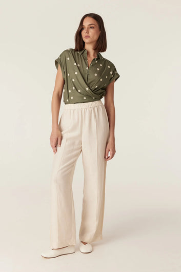 Cable Melbourne Muse Spring Blouse in Green Spot print, worn with cream wide-leg trousers - front view
