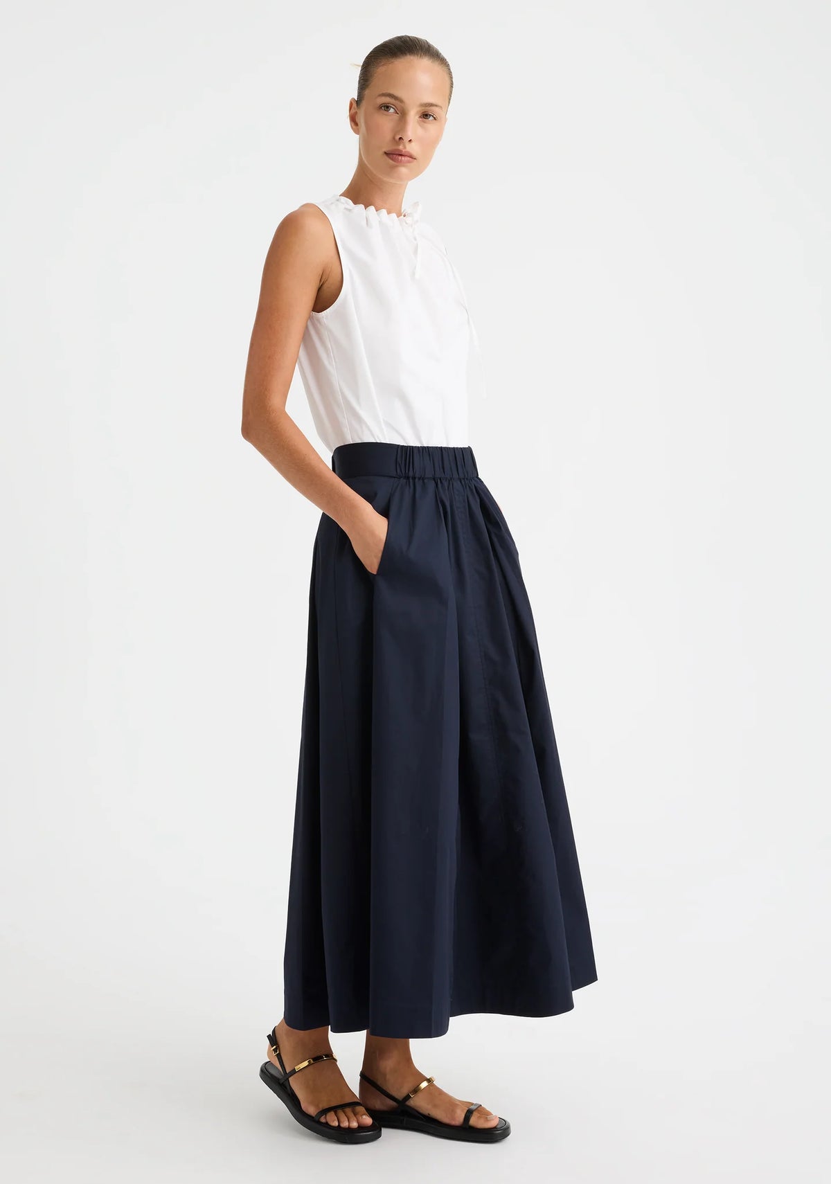 Morrison Maddison Skirt in Navy, worn - three-quarter view, hand in pocket